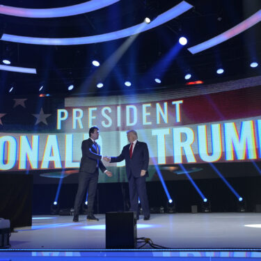 FILE - Former President Donald Trump, right, shakes hands with Turning Point CEO Charlie Kirk before speaking during the Turning Point USA Student Action Summit, Saturday, July 23, 2022, in Tampa, Fla. (AP Photo/Phelan M. Ebenhack, File)