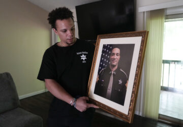 Lij Hacker holds a photo of his late brother, Asson Hacker, during an interview in Bloomington, Ind., on June 4, 2024. (AP Photo/Darron Cummings)