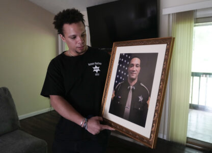 Lij Hacker holds a photo of his late brother, Asson Hacker, during an interview in Bloomington, Ind., on June 4, 2024. (AP Photo/Darron Cummings)