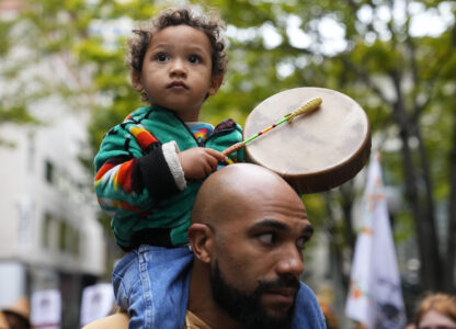 FILE - Khalako Lloyd, 2, of the Mandan and Hidatsa tribes, beats on a drum while carried on the shoulder of his father, Julius Lloyd during a celebratory march for Indigenous Peoples Day, Oct. 9, 2023, in Seattle. (AP Photo/Lindsey Wasson, File)