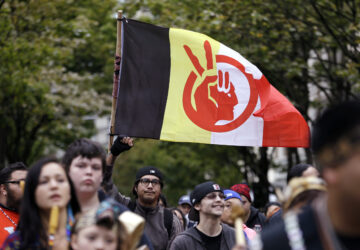 FILE - An American Indian Movement flag is flow during a march for Indigenous Peoples Day, Oct. 12, 2015, in Seattle. (AP Photo/Elaine Thompson, File)