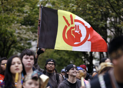 FILE - An American Indian Movement flag is flow during a march for Indigenous Peoples Day, Oct. 12, 2015, in Seattle. (AP Photo/Elaine Thompson, File)