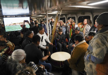 Passengers play drums and chant on the way by ferry to Alcatraz Island on Indigenous Peoples Day Monday, Oct. 14, 2024, in San Francisco. (AP Photo/Minh Connors)