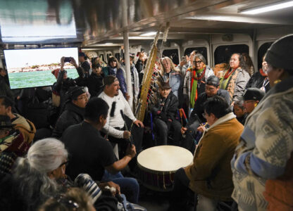 Passengers play drums and chant on the way by ferry to Alcatraz Island on Indigenous Peoples Day Monday, Oct. 14, 2024, in San Francisco. (AP Photo/Minh Connors)