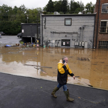 FILE - A man walks near a flooded area near the Swannanoa river, effects from Hurricane Helene , Friday, Sept. 27, 2024, in Asheville, N.C. (AP Photo/Erik Verduzco, File)