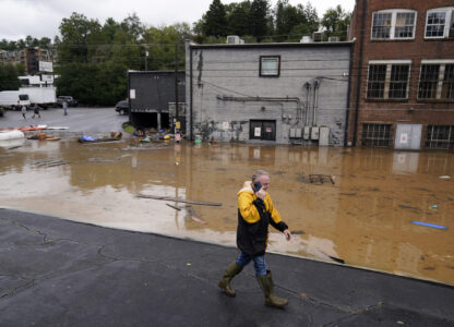 FILE - A man walks near a flooded area near the Swannanoa river, effects from Hurricane Helene , Friday, Sept. 27, 2024, in Asheville, N.C. (AP Photo/Erik Verduzco, File)