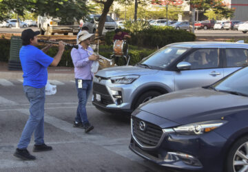 Musicians play for tips from motorists in Culiacan, Sinaloa state, Mexico, Monday, Oct. 14, 2024. (AP Photo)