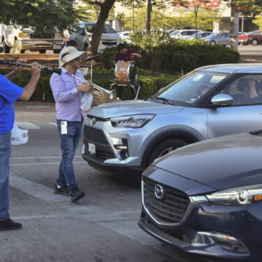 Musicians play for tips from motorists in Culiacan, Sinaloa state, Mexico, Monday, Oct. 14, 2024. (AP Photo)