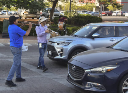 Musicians play for tips from motorists in Culiacan, Sinaloa state, Mexico, Monday, Oct. 14, 2024. (AP Photo)