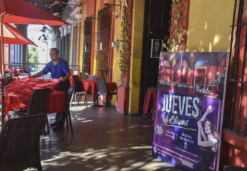 A waiter arranges a table outside the restaurant The Old Portales of Culiacan where a sign advertises two-for-one prices on drinks for women on Thursdays, in Culiacan, Sinaloa state, Mexico, Monday, Oct. 14, 2024. (AP Photo)