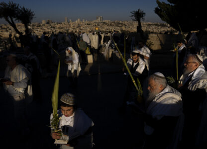 Ultra-Orthodox Jews wearing prayer shawls perform the Hoshana Rabbah prayer on the seventh day of the weeklong Jewish holiday of Sukkot at Mount of Olives overlooking Jerusalem's Old City with the Dome of the Rock shrine, Wednesday, Oct. 23, 2024. (AP Photo//Oded Balilty)