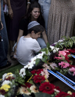 Relatives pause at the grave of Israel Defense Forces Captain Elad Siman Tov, who was killed in action in Lebanon, during his funeral in Petah Tikva, Israel, Friday, Oct. 18, 2024. (AP Photo/Maya Alleruzzo)