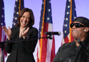 Democratic presidential nominee Vice President Kamala Harris listens as Stevie Wonder performs 