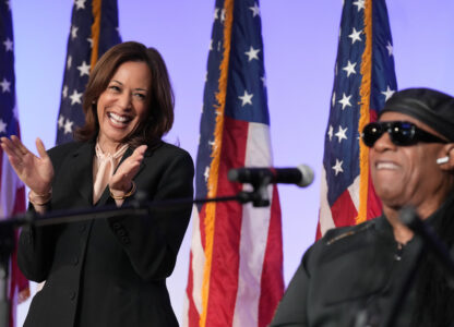 Democratic presidential nominee Vice President Kamala Harris listens as Stevie Wonder performs 