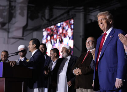 Republican presidential nominee former President Donald Trump, right, looks on as local Muslim leaders speak during a campaign rally at the Suburban Collection Showplace, Saturday, Oct. 26, 2024, in Novi, Mich. (AP Photo/Alex Brandon)