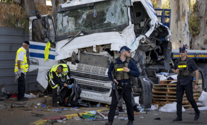 Israeli police and rescue services inspect the site where a truck driver rammed into a bus stop near an army base, wounding dozens of people, according to Israel's Magen David Adom rescue service in Ramat Hasharon, Israel, Sunday, Oct. 27, 2024. (AP Photo/Oded Balilty)