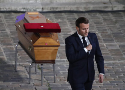 FILE - French President Emmanuel Macron leaves after paying his respects by the coffin of slain teacher Samuel Paty in the courtyard of the Sorbonne university during a national memorial event, Wednesday, Oct. 21, 2020 in Paris. (AP Photo/Francois Mori, Pool, File)