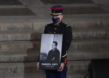 FILE - A Republican Guard holds a portrait of Samuel Paty in the courtyard of the Sorbonne university during a national memorial event, Wednesday, Oct. 21, 2020 in Paris. (AP Photo/Francois Mori, Pool, File)