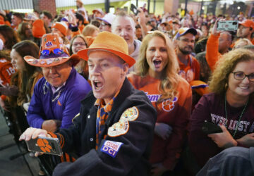 FILE - Clemson fans cheer on the Tigers as they arrive at Williams-Brice Stadium before an NCAA college football game against South Carolina Saturday, Nov. 27, 2021, in Columbia, S.C. (AP Photo/Sean Rayford, File)