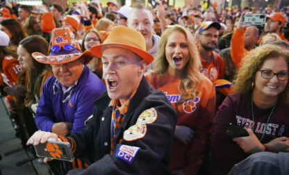 FILE - Clemson fans cheer on the Tigers as they arrive at Williams-Brice Stadium before an NCAA college football game against South Carolina Saturday, Nov. 27, 2021, in Columbia, S.C. (AP Photo/Sean Rayford, File)