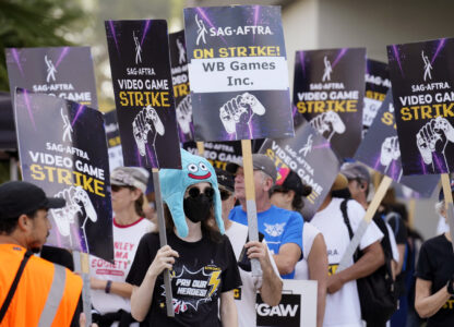 FILE - Actor Sena Bryer, second from left, joins other demonstrators in a SAG-AFTRA video game actor strike picket line outside Warner Bros. Studios on Aug. 28, 2024, in Burbank, Calif. (AP Photo/Chris Pizzello)