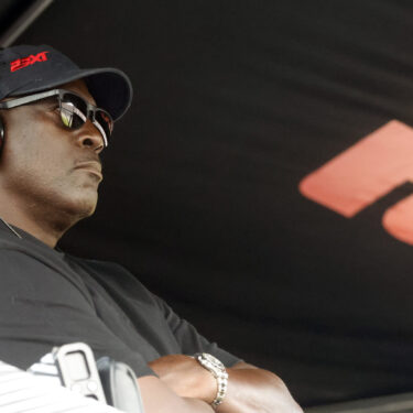 Michael Jordan, co-owner of 23XI Racing, sits in his pit box during a NASCAR Cup Series auto race at Talladega Superspeedway, Sunday, Oct. 6, 2024, in Talladega, Ala. (AP Photo/ Butch Dill)