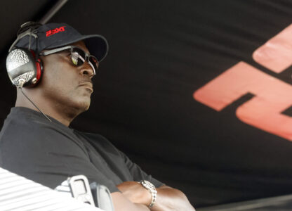 Michael Jordan, co-owner of 23XI Racing, sits in his pit box during a NASCAR Cup Series auto race at Talladega Superspeedway, Sunday, Oct. 6, 2024, in Talladega, Ala. (AP Photo/ Butch Dill)