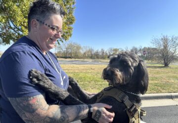 Air Force Staff Sgt. Heather O'Brien holds her labradoodle service dog, Albus, on Thursday, Nov. 7, 2024, in Kansas City, Kan. O'Brien is a part of Dogs 4 Valor that helps retired veterans and first responders in the Kansas City area work with their service dogs to help manage depression, anxiety and other challenges. (AP Photo/Nick Ingram)