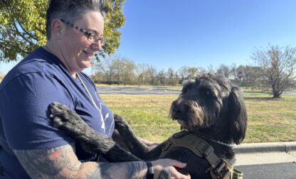 Air Force Staff Sgt. Heather O'Brien holds her labradoodle service dog, Albus, on Thursday, Nov. 7, 2024, in Kansas City, Kan. O'Brien is a part of Dogs 4 Valor that helps retired veterans and first responders in the Kansas City area work with their service dogs to help manage depression, anxiety and other challenges. (AP Photo/Nick Ingram)