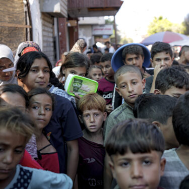 FILE - Palestinians line up for food distribution in Deir al-Balah, Gaza Strip, on Oct. 17, 2024. (AP Photo/Abdel Kareem Hana, File)