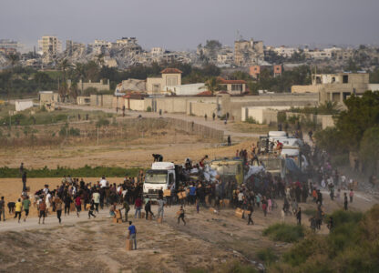 FILE - Palestinians are storming trucks loaded with humanitarian aid brought in through a new U.S.-built pier, in the central Gaza Strip, on May 18, 2024. (AP Photo/Abdel Kareem Hana, File)