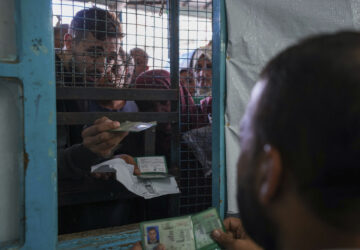 FILE - Palestinians line up to receive aid distributed by UNRWA, the U.N. agency helping Palestinian refugees, in Nusairat refugee camp, Gaza, on Nov. 5, 2024. (AP Photo/Abdel Kareem Hana, File)