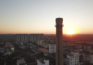 The sun sets near the smokestack of an abandoned factory of Dacheng Shenghua Feed company in Changchun, a city located in northwestern China's industrial rustbelt zone Jilin province on Oct. 12, 2024. (AP Photo/Dake Kang)