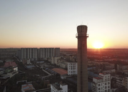 The sun sets near the smokestack of an abandoned factory of Dacheng Shenghua Feed company in Changchun, a city located in northwestern China's industrial rustbelt zone Jilin province on Oct. 12, 2024. (AP Photo/Dake Kang)