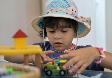 Palestinian girl Halima Abou Yassine, 7, who was brought to Lebanon from Gaza Strip for treatment after an Israeli strike left her near death with a gaping wound in her skull, plays with a toy car at a summer camp in Beirut, Lebanon, Friday, Aug. 30, 2024. (AP Photo/Bilal Hussein)