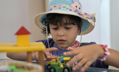 Palestinian girl Halima Abou Yassine, 7, who was brought to Lebanon from Gaza Strip for treatment after an Israeli strike left her near death with a gaping wound in her skull, plays with a toy car at a summer camp in Beirut, Lebanon, Friday, Aug. 30, 2024. (AP Photo/Bilal Hussein)