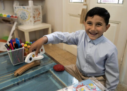 Palestinian Adam Afana, 5, who was brought to Lebanon from Gaza Strip for treatment who had nearly lost his left arm in an Israeli airstrike that killed his father and sister, plays with a toy plane at a summer camp in Beirut, Lebanon, Friday, Aug. 30, 2024. (AP Photo/Bilal Hussein)