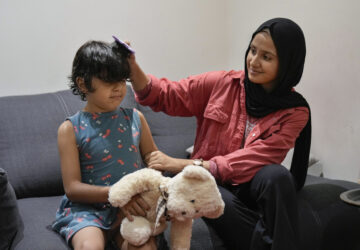 Siwar Abou Yassine, right, combs the hair of her sister Halima, 7, who was brought to Lebanon from Gaza for treatment after an Israeli strike left her near death with a gaping wound in her skull, in Beirut, Lebanon, Friday, Aug. 30, 2024. (AP Photo/Bilal Hussein)