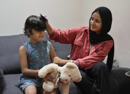 Siwar Abou Yassine, right, combs the hair of her sister Halima, 7, who was brought to Lebanon from Gaza for treatment after an Israeli strike left her near death with a gaping wound in her skull, in Beirut, Lebanon, Friday, Aug. 30, 2024. (AP Photo/Bilal Hussein)