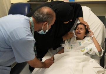 Palestinian girl Halima Abou Yassine, 7, who was brought to Lebanon from Gaza for treatment after an Israeli strike left her near death with a gaping wound in her skull, cries as she lies on a hospital bed ahead of a surgery on her head at the American University of Beirut Medical Center (AUBMC), in Beirut, Lebanon, Monday, July 15, 2024. (AP Photo/Hussein Malla)