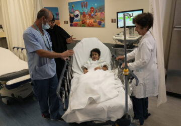 Halima Abou Yassine, 7, who was brought to Lebanon from Gaza for treatment after an Israeli strike left her near death with a gaping wound in her skull, lies on a hospital bed as she is moved by nurses to the operating room for surgery at the American University of Beirut Medical Center in Beirut, Lebanon, Monday, July 15, 2024. (AP Photo/Hussein Malla)