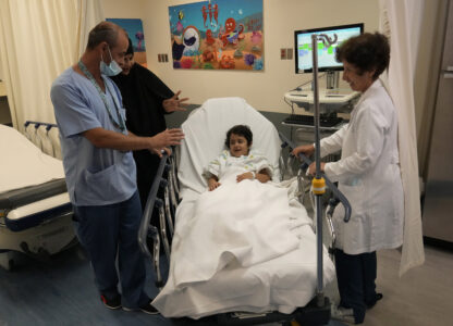 Halima Abou Yassine, 7, who was brought to Lebanon from Gaza for treatment after an Israeli strike left her near death with a gaping wound in her skull, lies on a hospital bed as she is moved by nurses to the operating room for surgery at the American University of Beirut Medical Center in Beirut, Lebanon, Monday, July 15, 2024. (AP Photo/Hussein Malla)