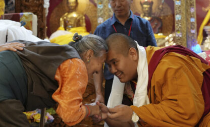 U.S.-born Buddhist lama, Jalue Dorje, right, and a member of the Minnesota Tibetan community bow and touch foreheads in a traditional Tibetan greeting at his 18th birthday and enthronement ceremony in Isanti, Minn., on Saturday, Nov. 9, 2024. (AP Photo/Luis Andres Henao)