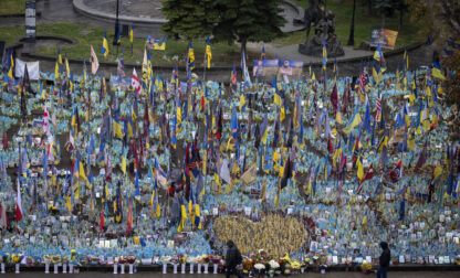 People walk past the memorial to fallen soldiers in Independence Square in Kyiv, Ukraine, Friday, Nov. 15, 2024. (AP Photo/Efrem Lukatsky)