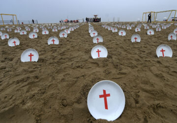 Plates marked with crosses, symbolizing people suffering from hunger worldwide, are displayed at Copacabana Beach during a protest aimed at drawing the attention of leaders attending the upcoming G20 summit in Rio de Janeiro, Saturday, Nov. 16, 2024. (AP Photo/Dhavid Normando)