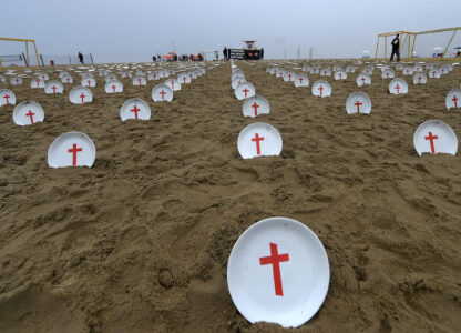 Plates marked with crosses, symbolizing people suffering from hunger worldwide, are displayed at Copacabana Beach during a protest aimed at drawing the attention of leaders attending the upcoming G20 summit in Rio de Janeiro, Saturday, Nov. 16, 2024. (AP Photo/Dhavid Normando)