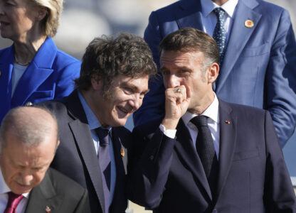 Argentina's President Javier Milei, left, and France's President Emmanuel Macron talk during a group photo at the G20 Summit in Rio de Janeiro, Monday, Nov. 18, 2024. (AP Photo/Eraldo Peres)