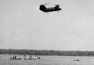 FiLE - Military rescue workers and boaters arrive on the scene of a crash, shortly after it happened, of an experimental V-22 Osprey tilt-rotor aircraft in the Potomac River just off the Quantico Marine Air Station, July 20, 1992, in Quantico, Va. (AP Photo/Bill Kramer)