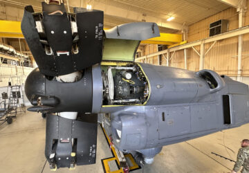 A service member walks under the Osprey nacelle, which houses both the Osprey's engine and transmission system and bends upward like an elbow during vertical flight at Cannon Air Force Base, N.M., Oct. 8, 2024. The open panel shows the proprotor gearbox, which serves as the transmission and has been a factor in multiple crashes after parts wore down and broke apart in flight. (AP Photo/Tara Copp)