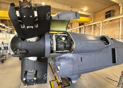 A service member walks under the Osprey nacelle, which houses both the Osprey's engine and transmission system and bends upward like an elbow during vertical flight at Cannon Air Force Base, N.M., Oct. 8, 2024. The open panel shows the proprotor gearbox, which serves as the transmission and has been a factor in multiple crashes after parts wore down and broke apart in flight. (AP Photo/Tara Copp)